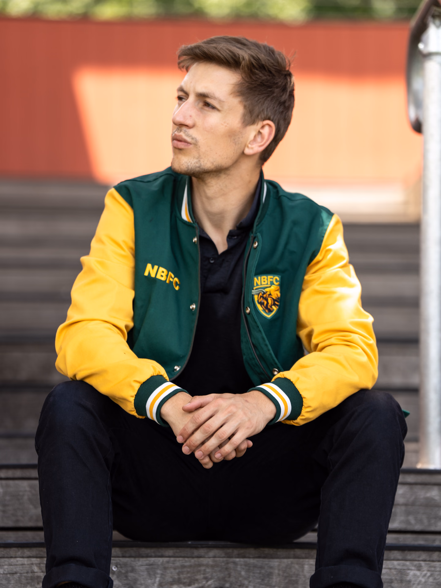 Model wearing a green and yellow Icon Sports club jacket